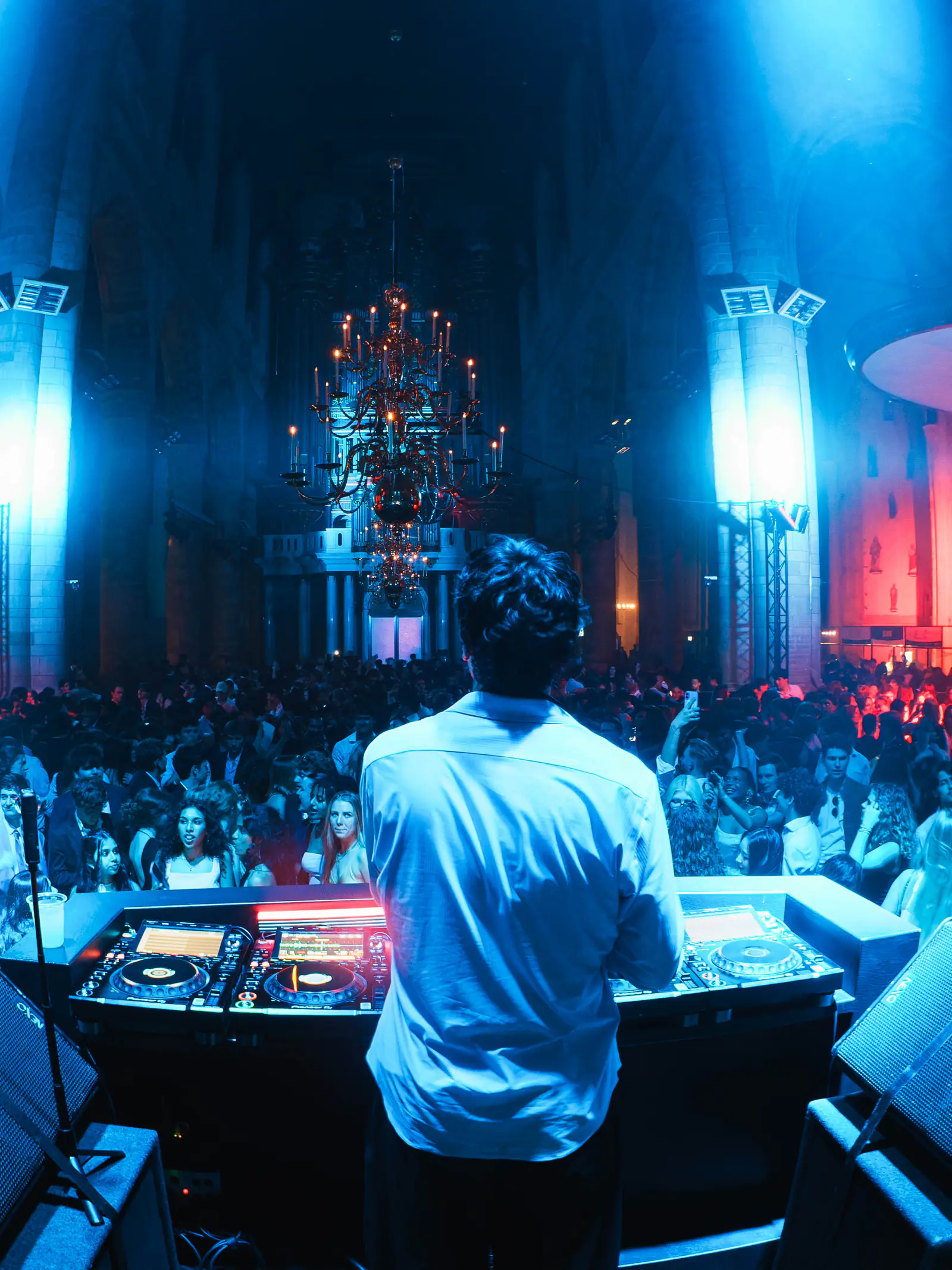 DJ booth facing a blue-lit Erasmus Gala crowd