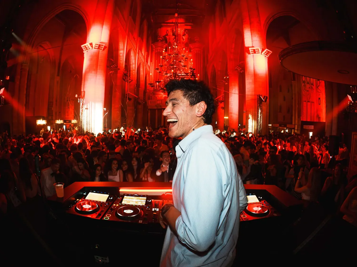 DJ performing at a red-lit music event