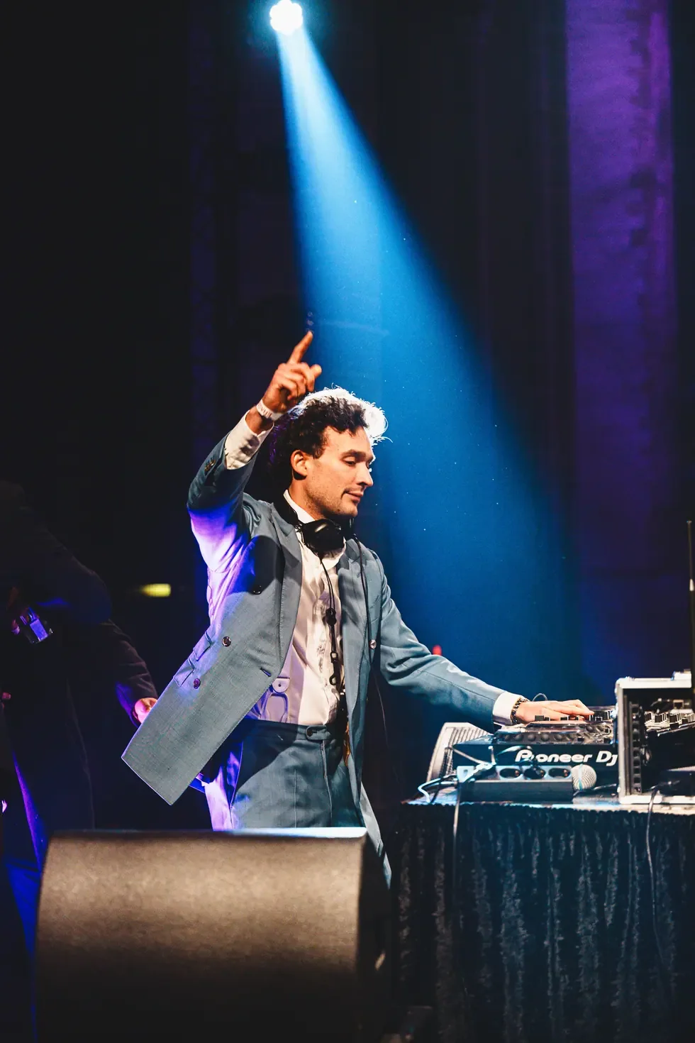 Artist performing behind DJ equipment