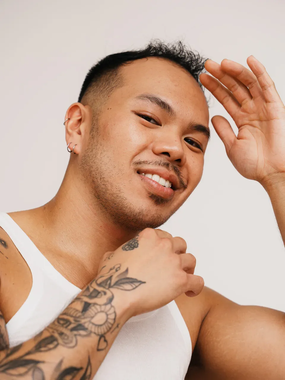 Expressive close studio portrait with visible tattoos