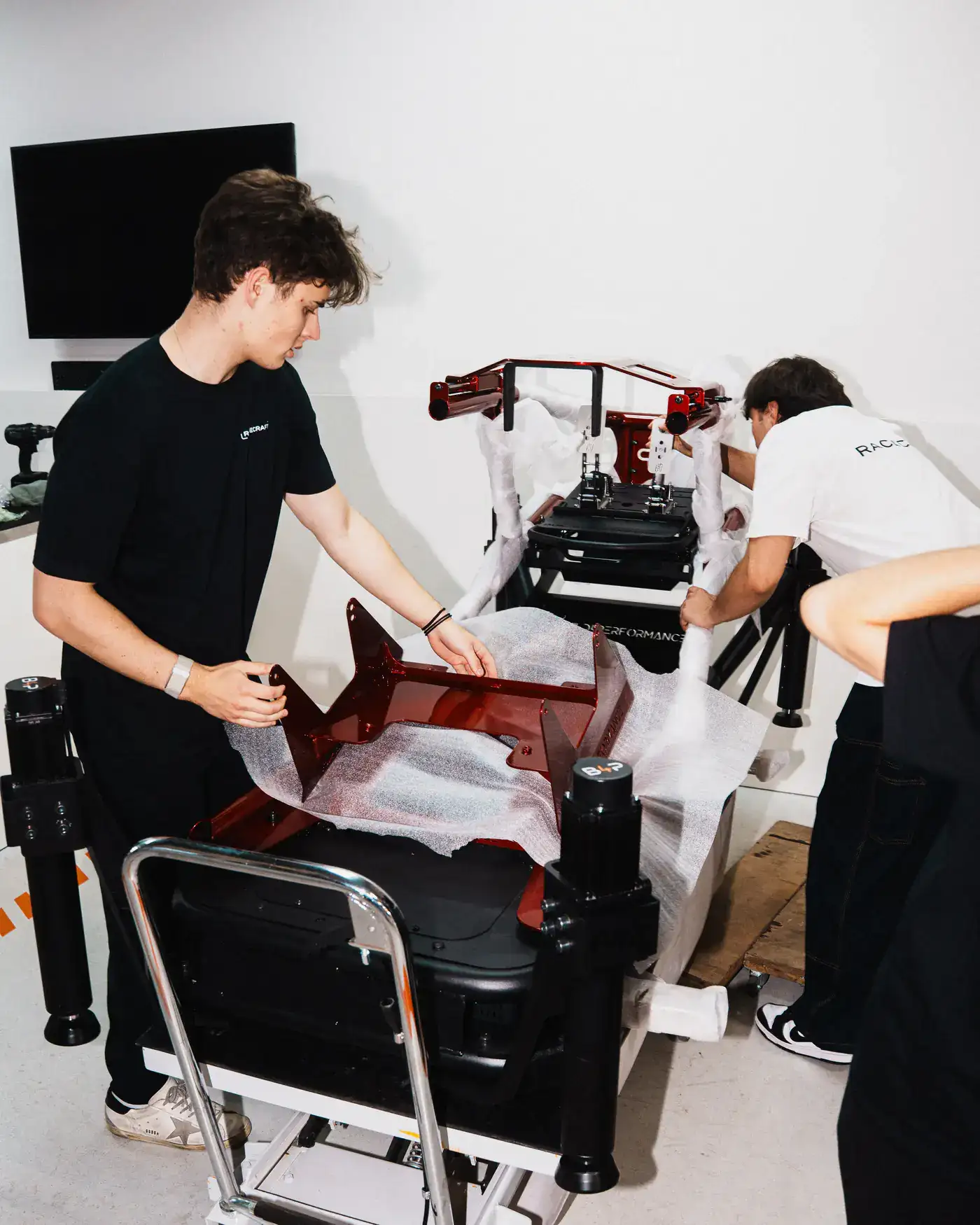 Racecraft team members preparing branded equipment in a workshop