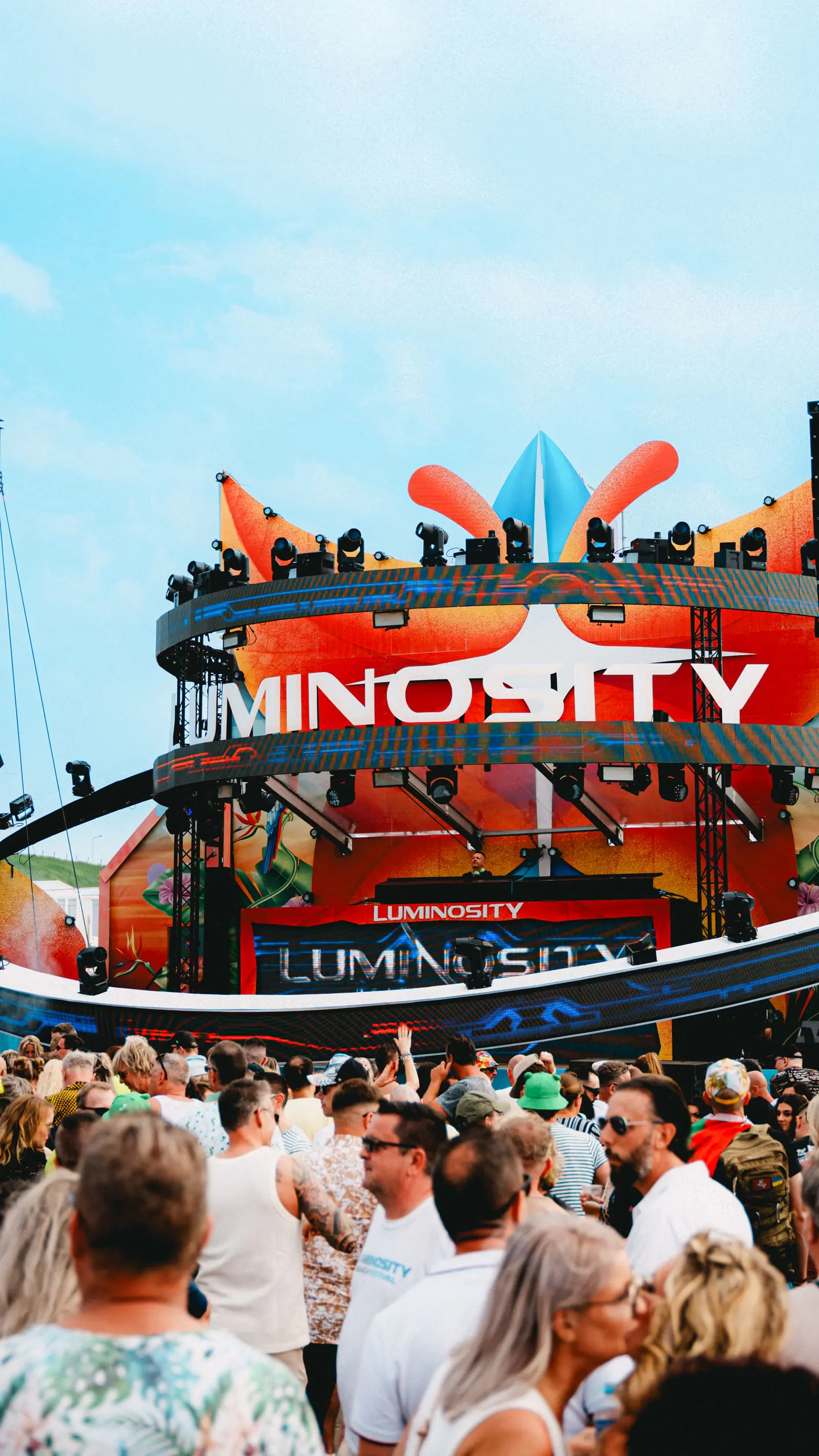 Outdoor festival crowd in front of a warm-lit stage